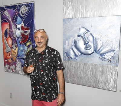 Oswaldo posing in front oh his paintings for Wild in the City
